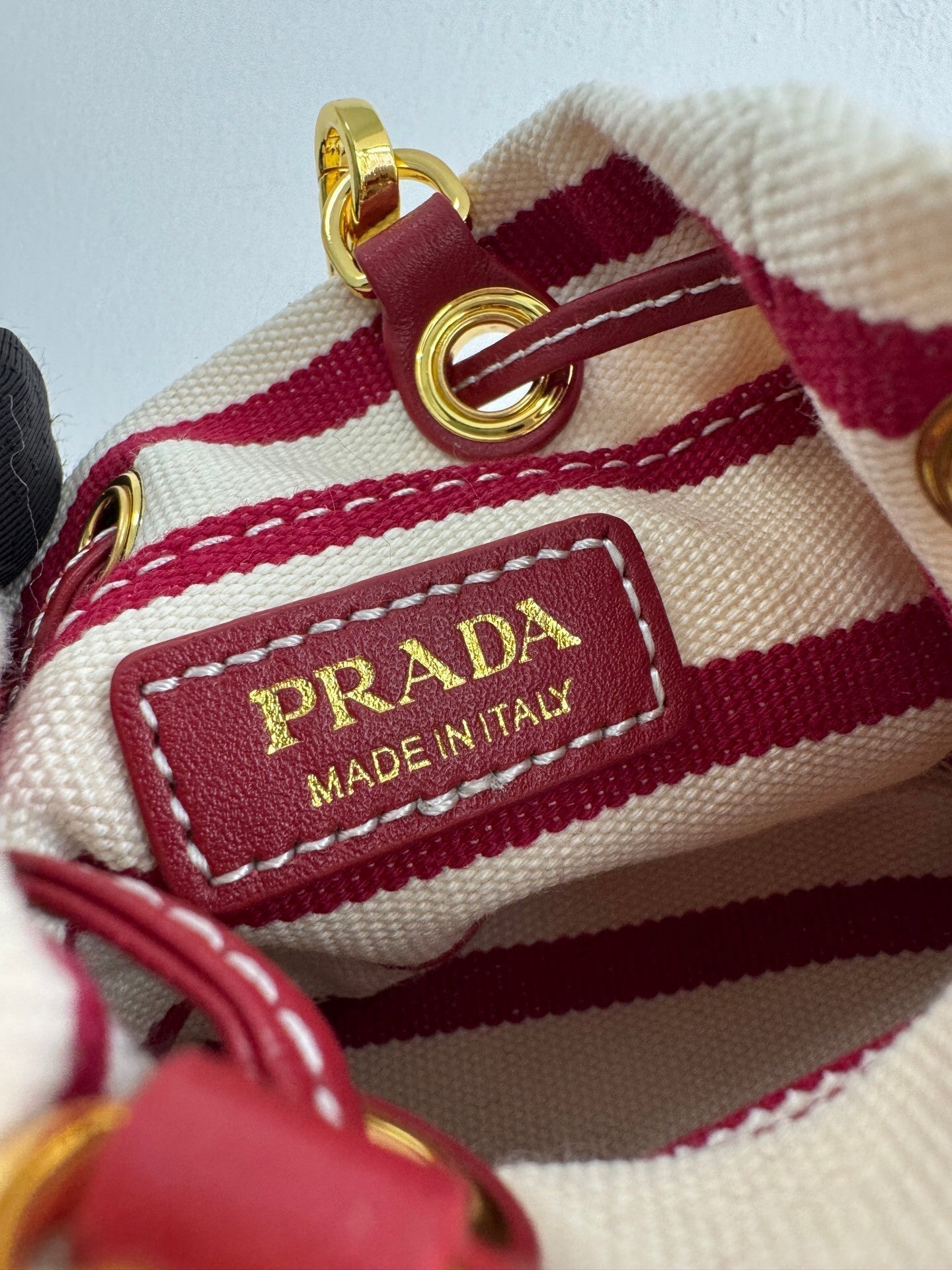 Gestreifte Mini-Beuteltasche aus Canvas mit goldenen Metallteilen