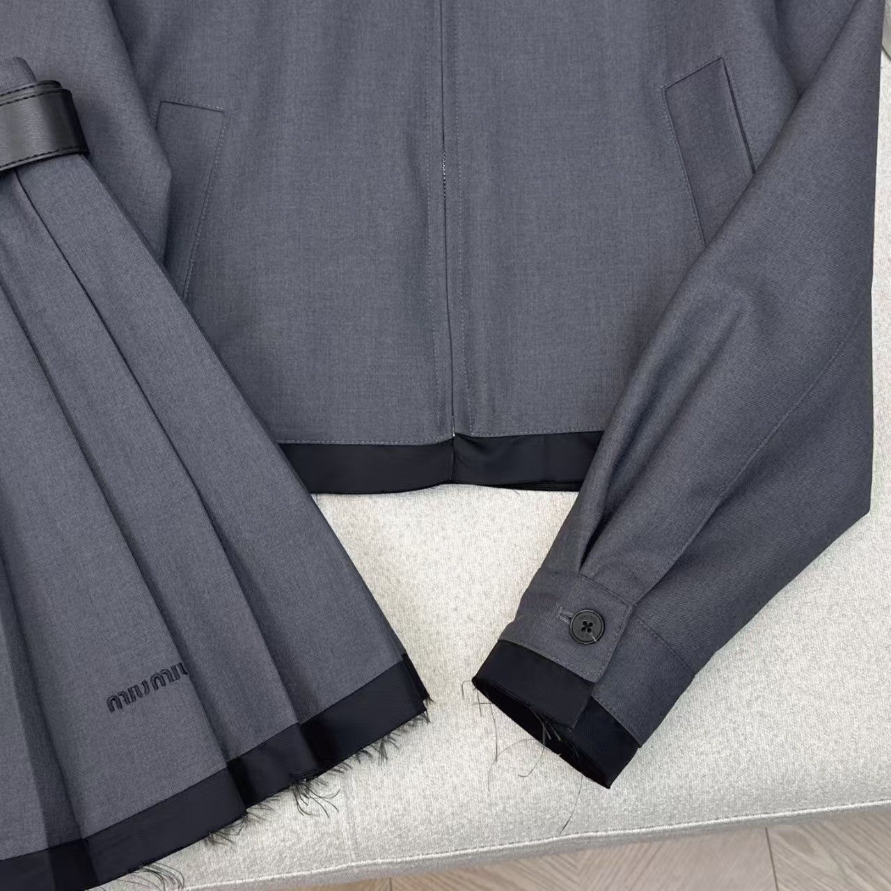 Anzug aus Jacke mit gespleißtem Revers und Faltenrock mit Gürtel