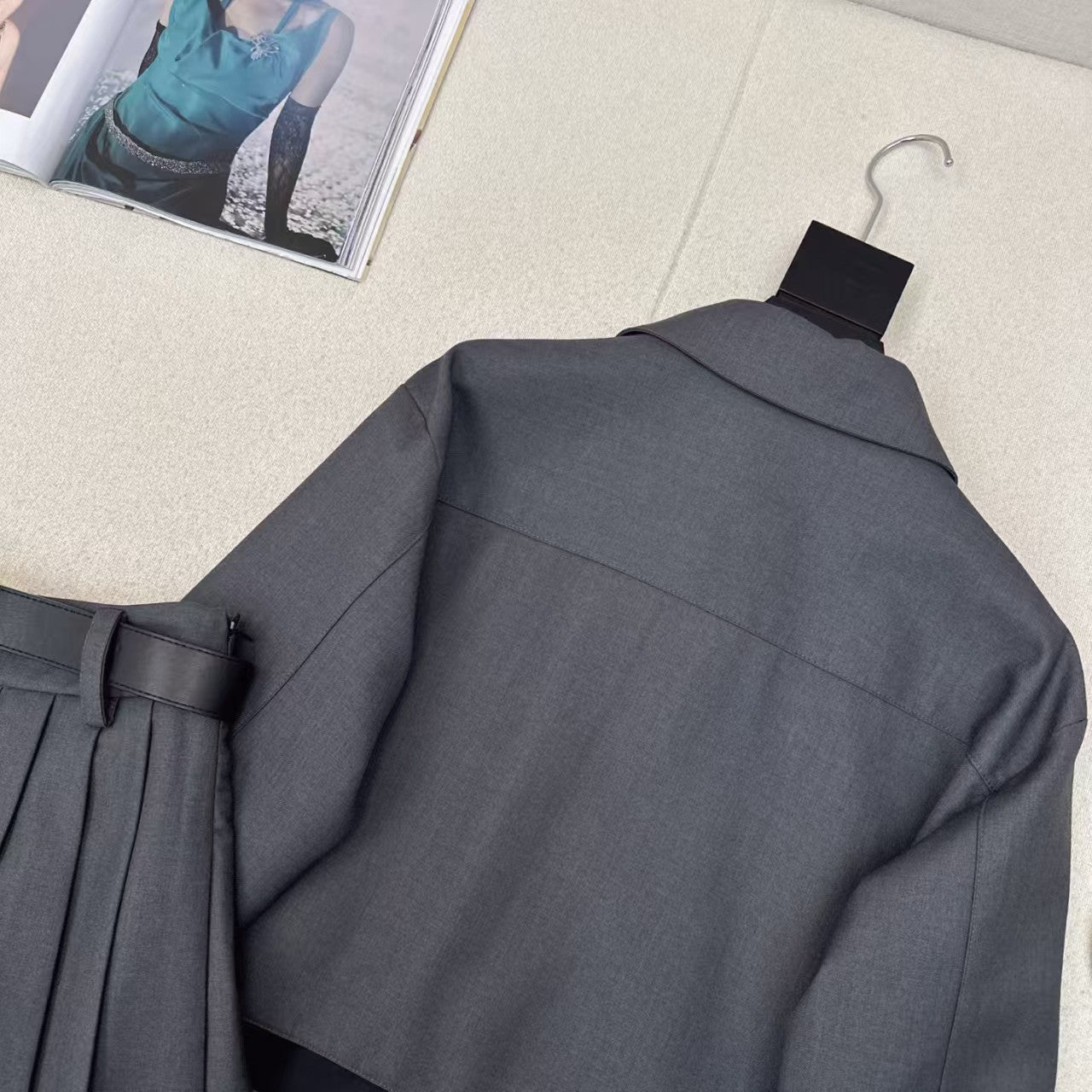 Anzug aus Jacke mit gespleißtem Revers und Faltenrock mit Gürtel