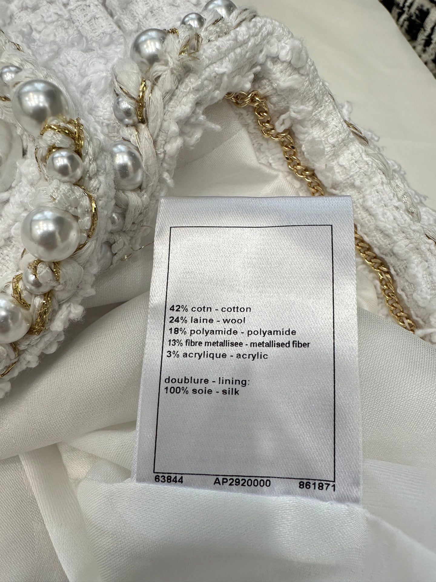 Veste courte à col en V et manches longues en tweed sergé blanc crème avec boutons et finitions en perles