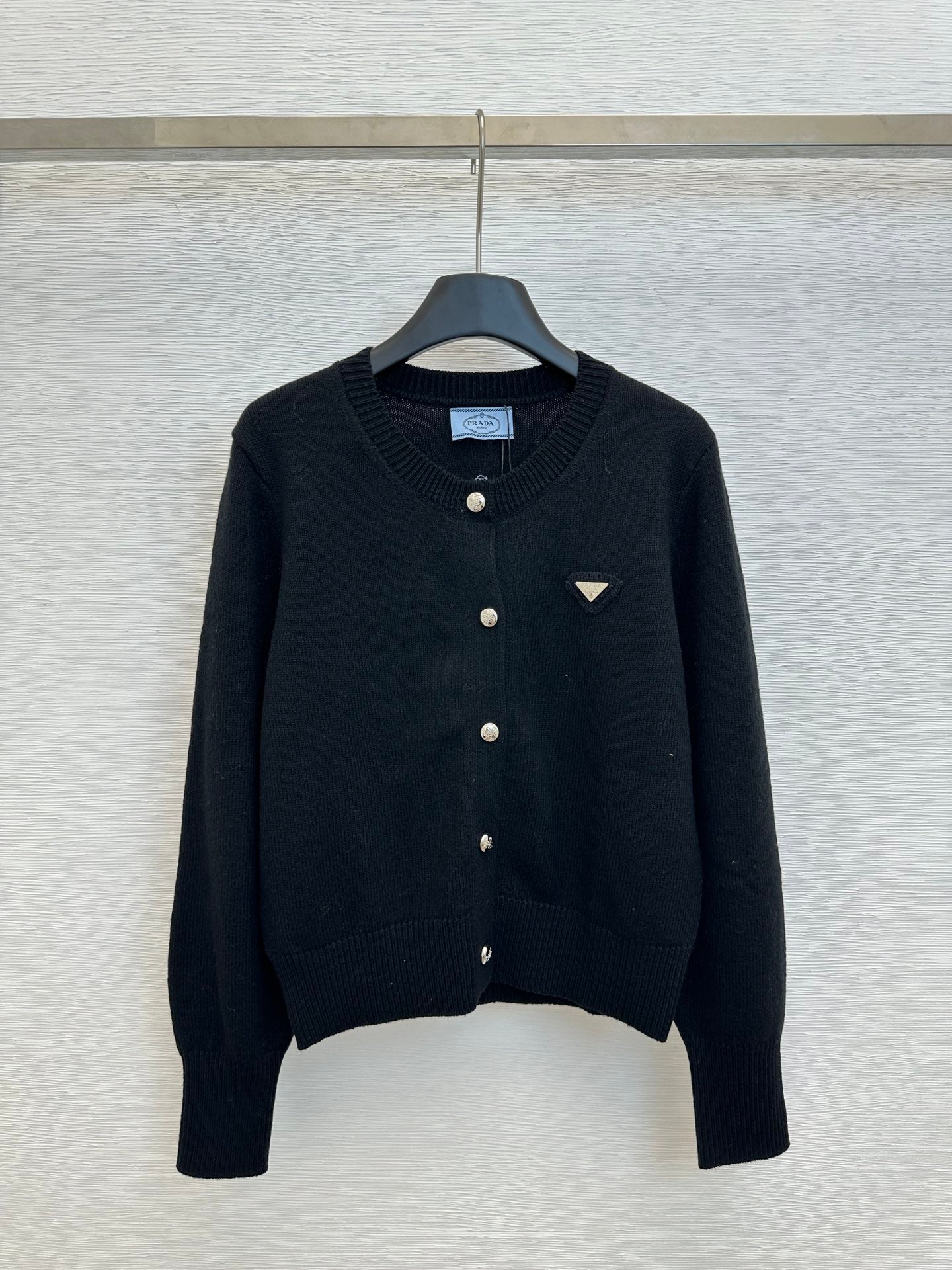 Gestrickte Strickjacke mit Rundhalsausschnitt und langen Ärmeln und gesticktem Relief auf der Rückseite