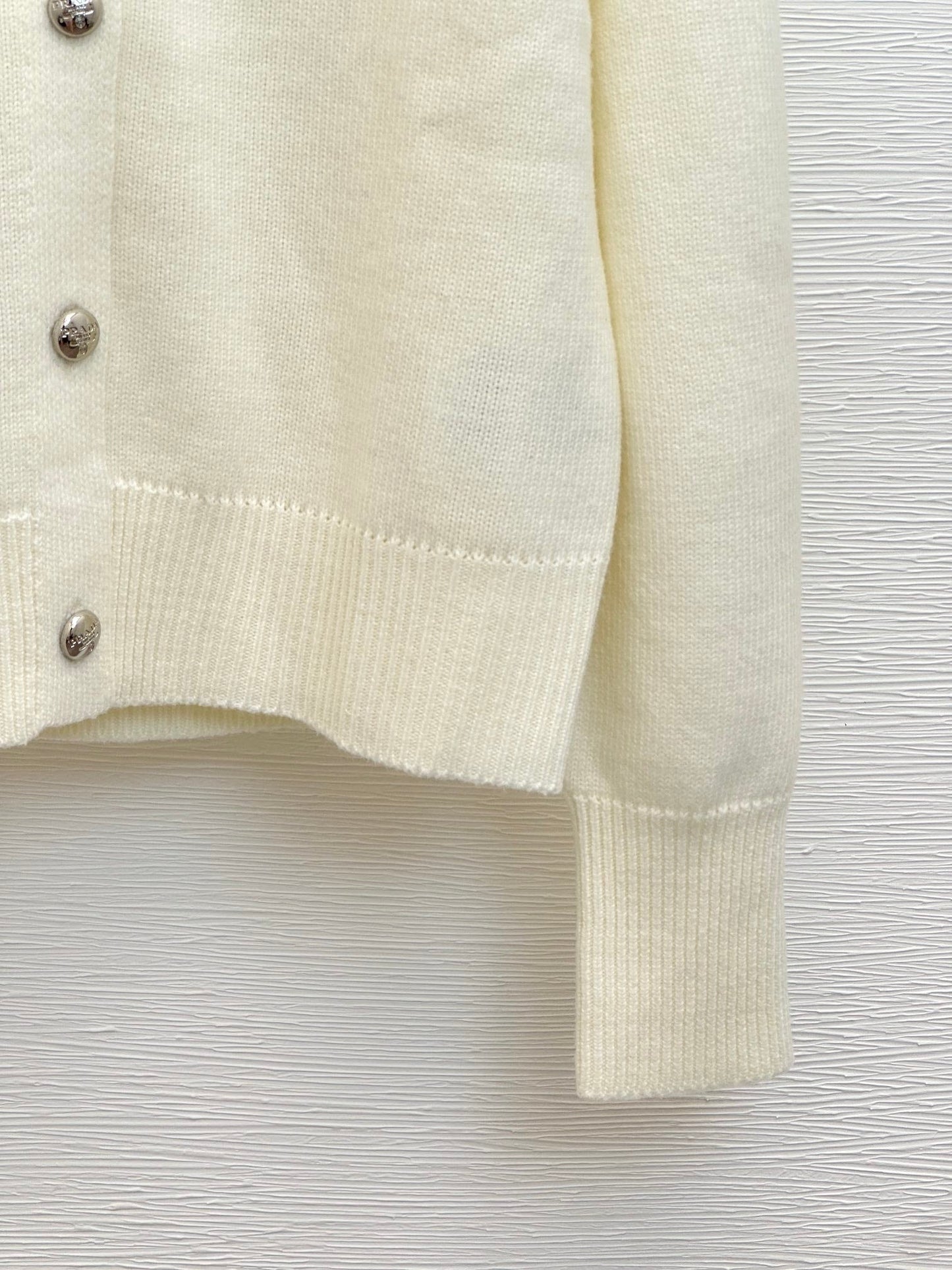 Gestrickte Strickjacke mit Rundhalsausschnitt und langen Ärmeln und gesticktem Relief auf der Rückseite