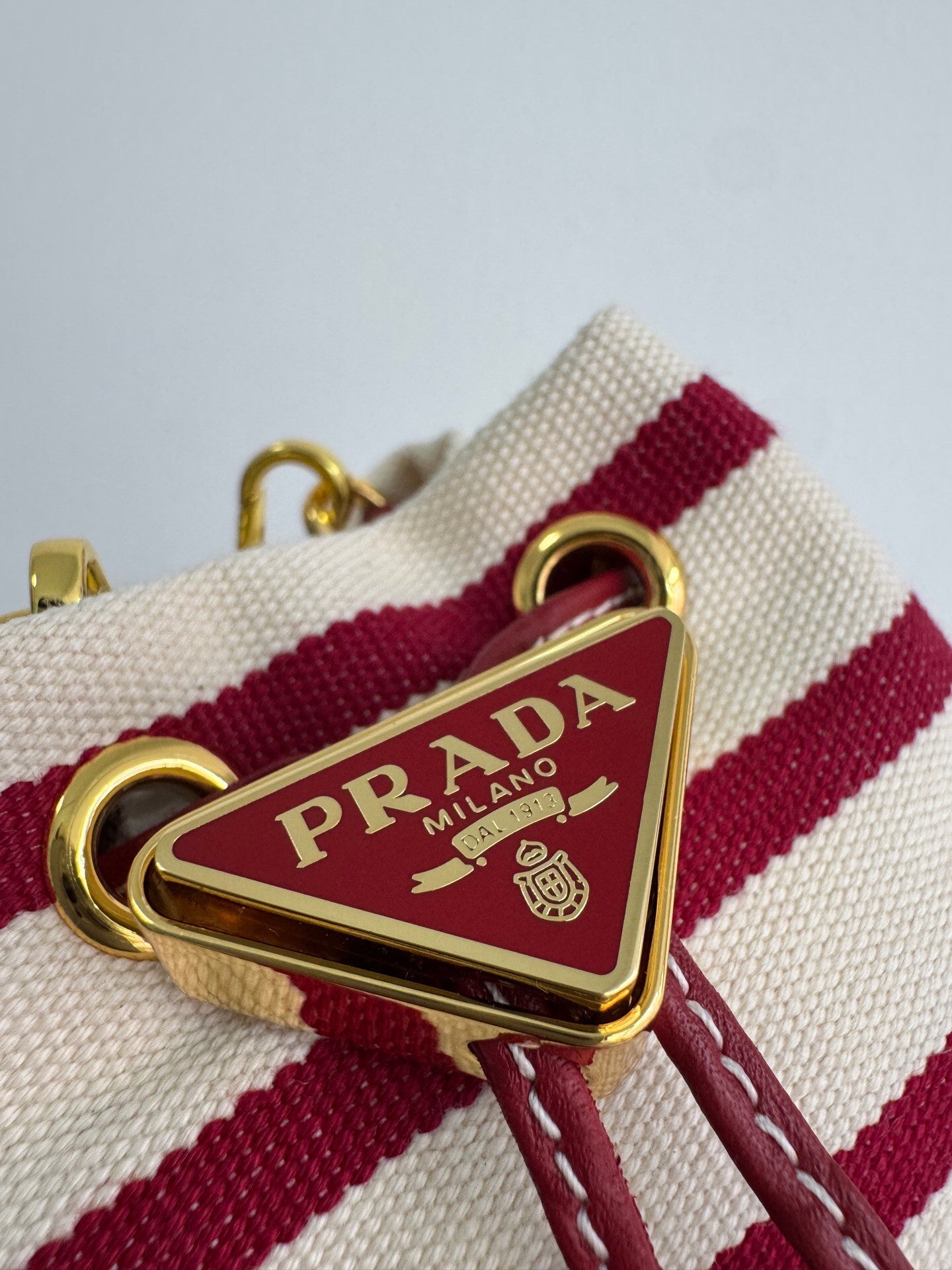 Gestreifte Mini-Beuteltasche aus Canvas mit goldenen Metallteilen 