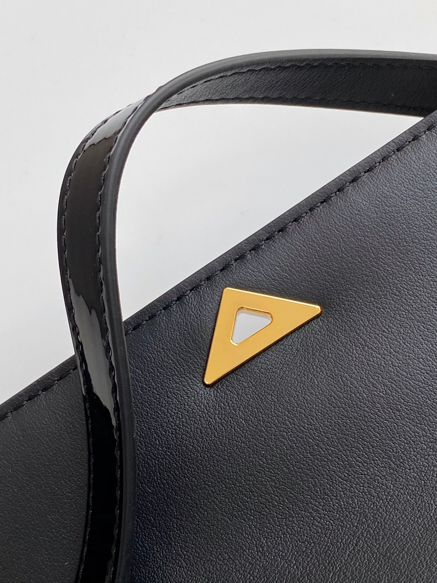 Sac baguette en cuir verni noir avec accents dorés 