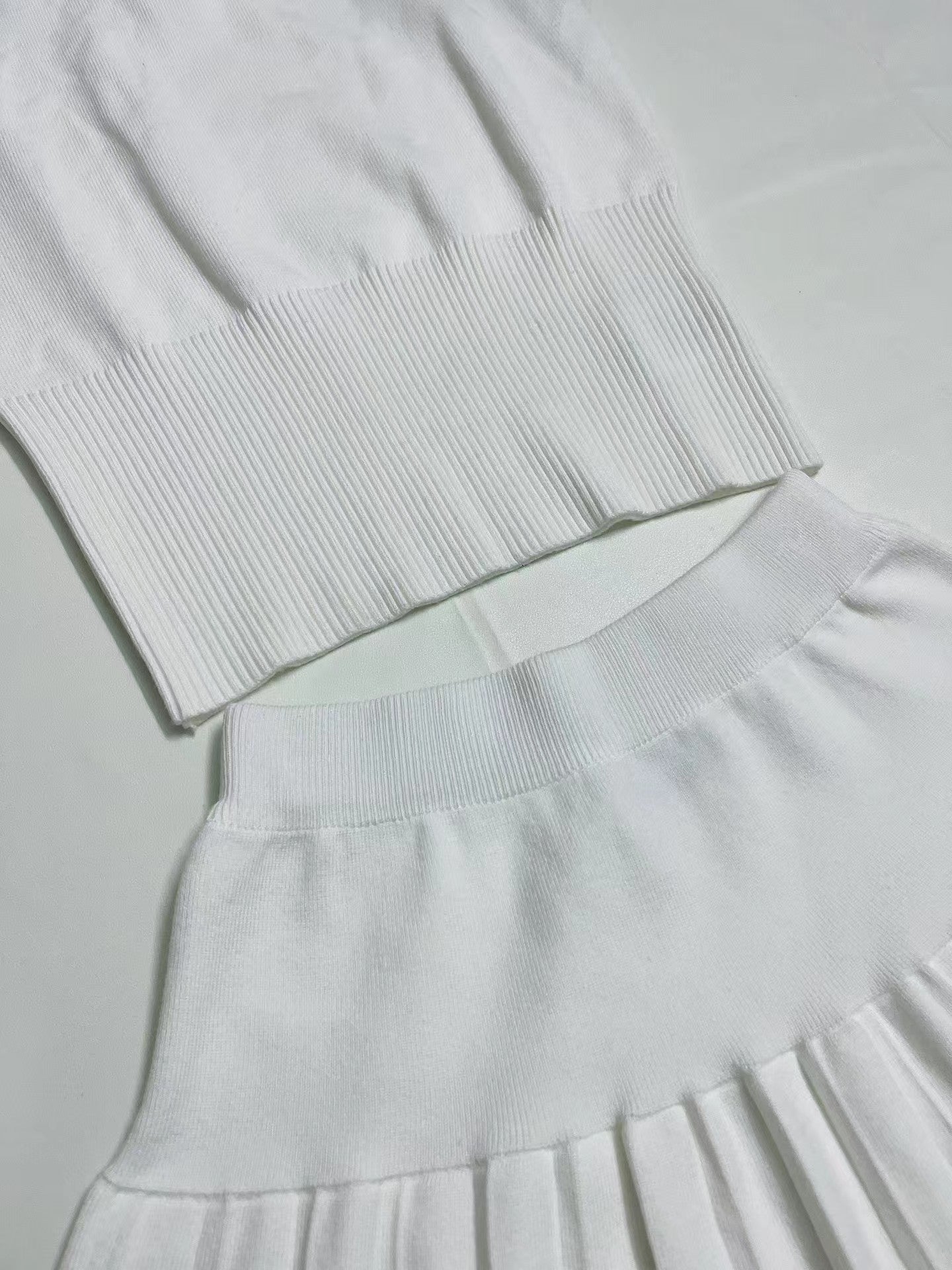 Neuer gestrickter Anzug aus schulterfreier Weste mit mittlerem Ausschnitt und kurzem Rock in Kontrastfarbe