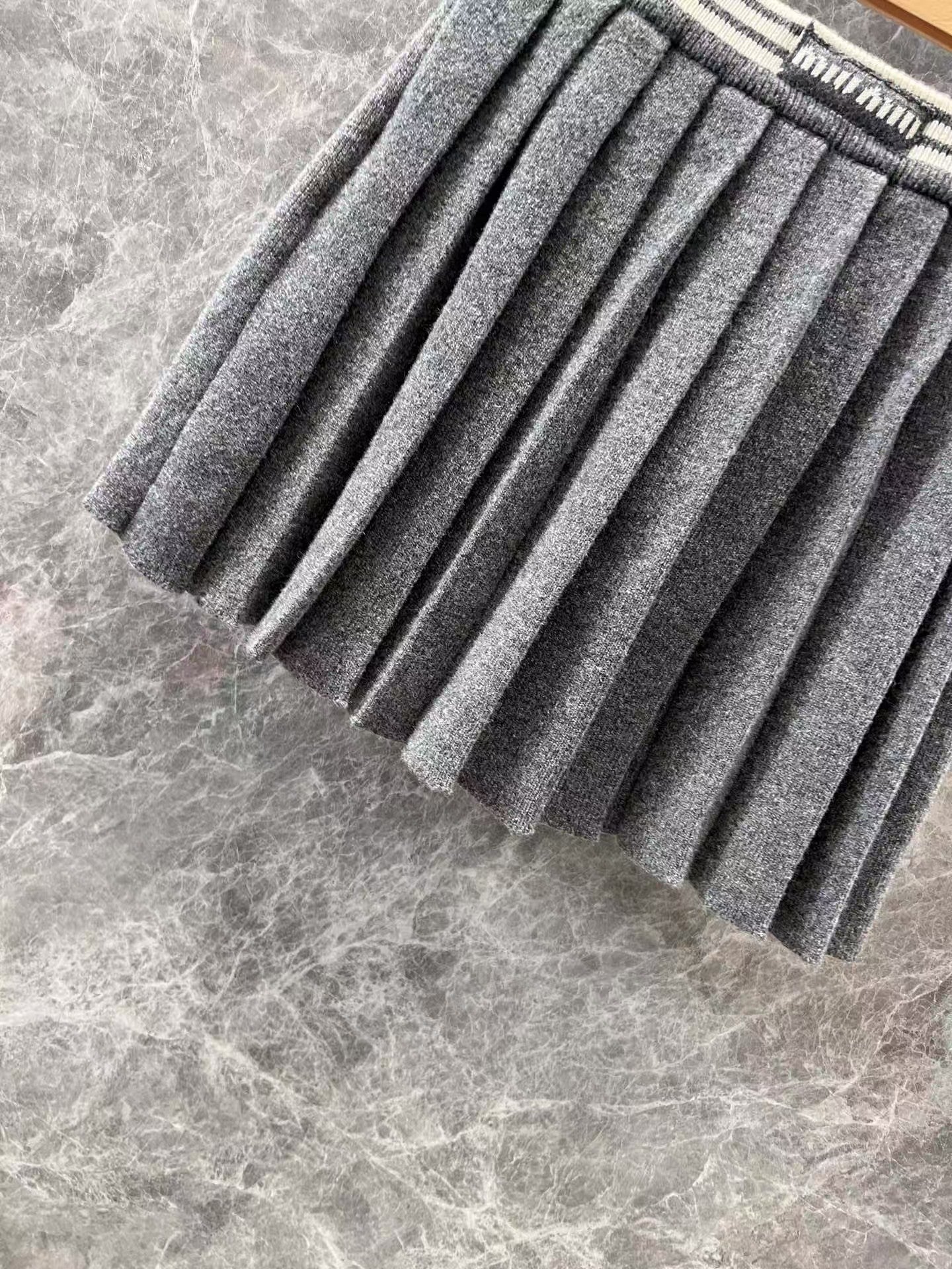 Tailleur jupe plissée à rayures contrastées avec logo brodé