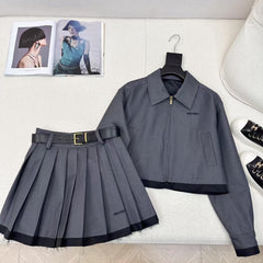 Tailleur veste à revers épissés et jupe plissée ceinturée