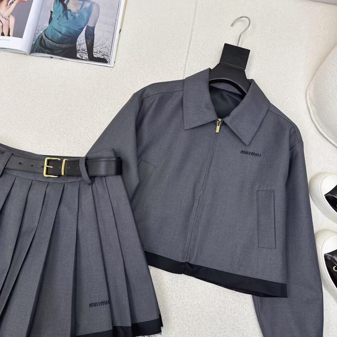 Anzug aus Jacke mit gespleißtem Revers und Faltenrock mit Gürtel