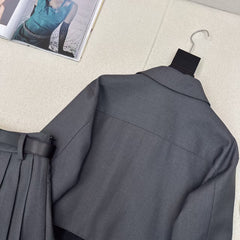 Tailleur veste à revers épissés et jupe plissée ceinturée