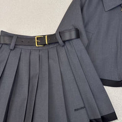 Tailleur veste à revers épissés et jupe plissée ceinturée
