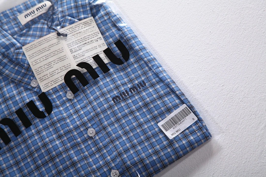 Hellblaues kariertes Hemd mit Pelzbesatz. Hemd mit kleinen karierten Ärmeln und Pelzbesatz. Kariertes Hemd