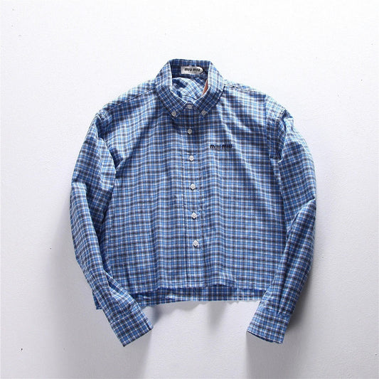 Hellblaues kariertes Hemd mit Pelzbesatz. Hemd mit kleinen karierten Ärmeln und Pelzbesatz. Kariertes Hemd