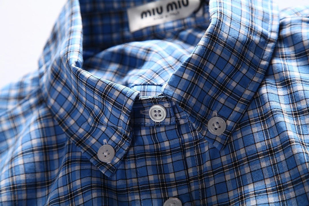 Hellblaues kariertes Hemd mit Pelzbesatz. Hemd mit kleinen karierten Ärmeln und Pelzbesatz. Kariertes Hemd