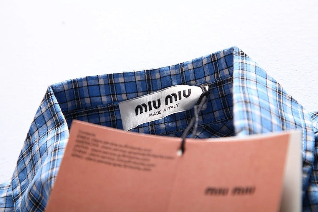 Hellblaues kariertes Hemd mit Pelzbesatz. Hemd mit kleinen karierten Ärmeln und Pelzbesatz. Kariertes Hemd