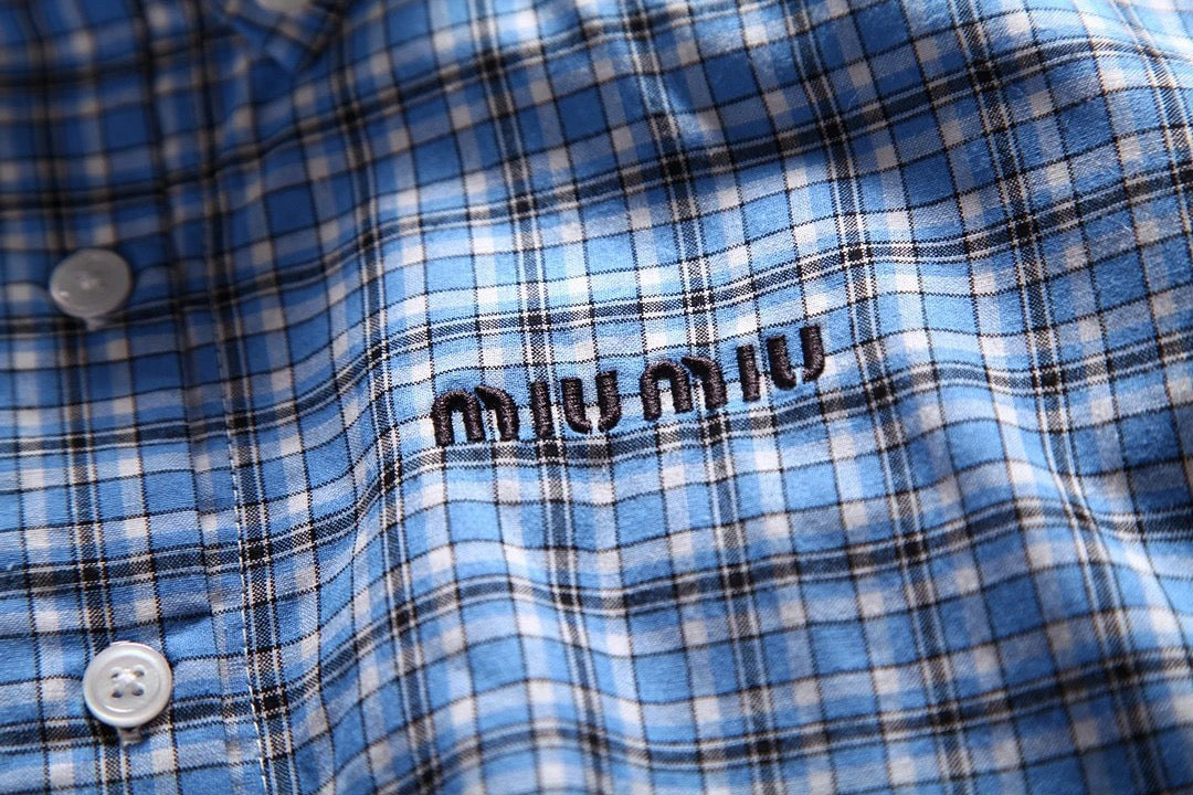 Hellblaues kariertes Hemd mit Pelzbesatz. Hemd mit kleinen karierten Ärmeln und Pelzbesatz. Kariertes Hemd