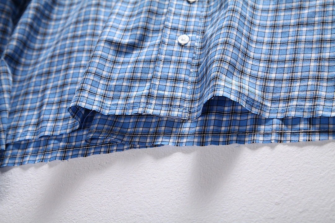 Hellblaues kariertes Hemd mit Pelzbesatz. Hemd mit kleinen karierten Ärmeln und Pelzbesatz. Kariertes Hemd