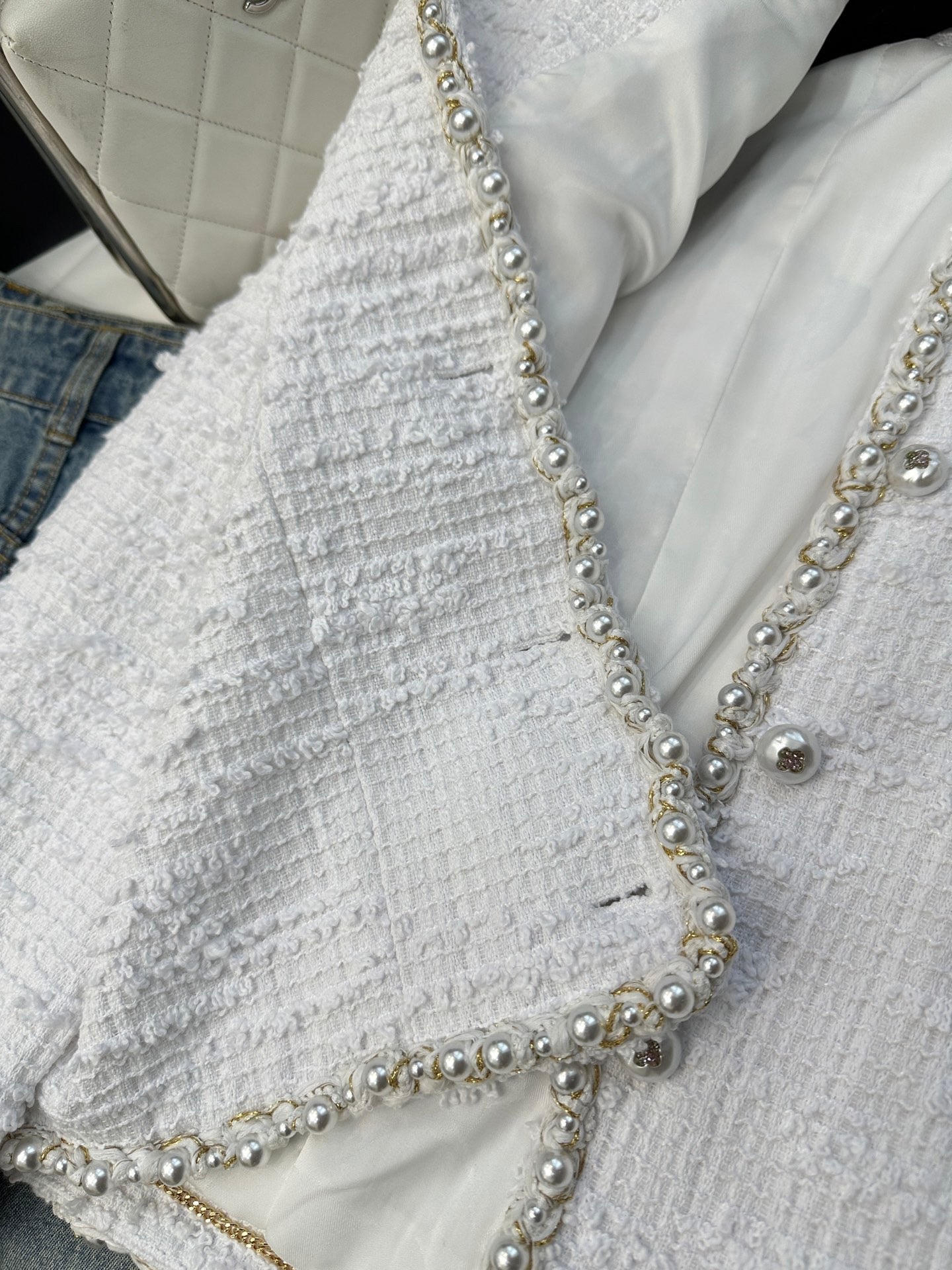 Veste courte à col en V et manches longues en tweed sergé blanc crème avec boutons et finitions en perles