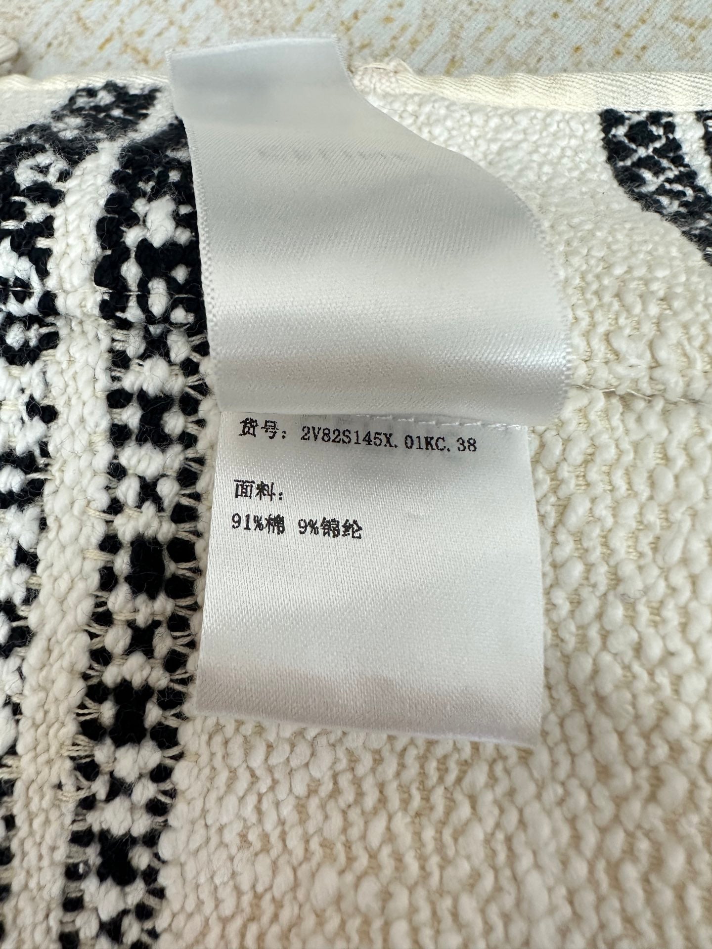 Jacke mit Rundhalsausschnitt und einreihigem Metallknopfmuster in Schwarz und Weiß